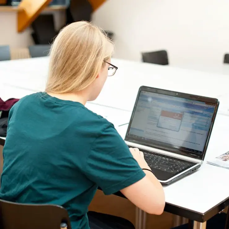 Eine Studentin sitzt in der Universitätsbibliothek