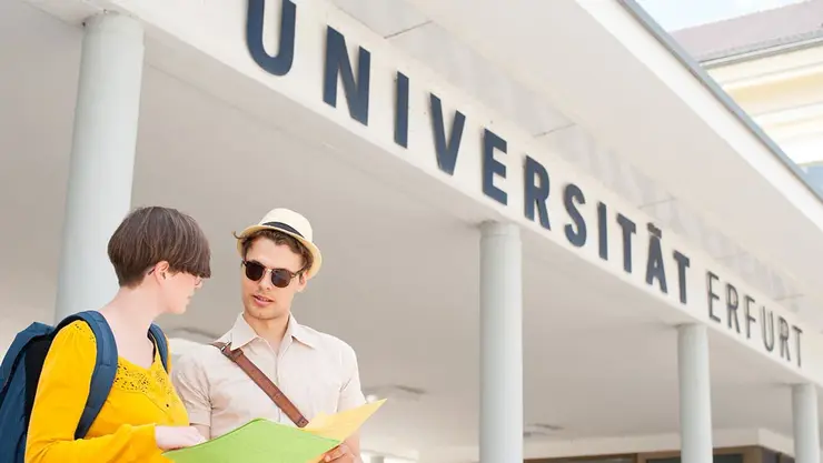 Studierende stehen vor dem Haupteingang zur Universität Erfurt