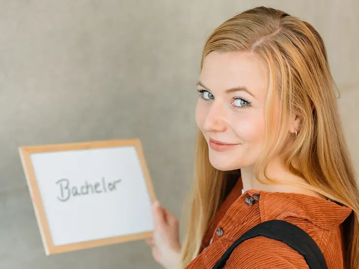 Bachelor-Studentin mit Schild