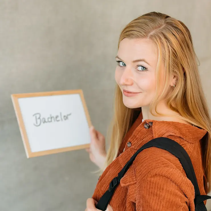 Bachelor-Studentin mit Schild