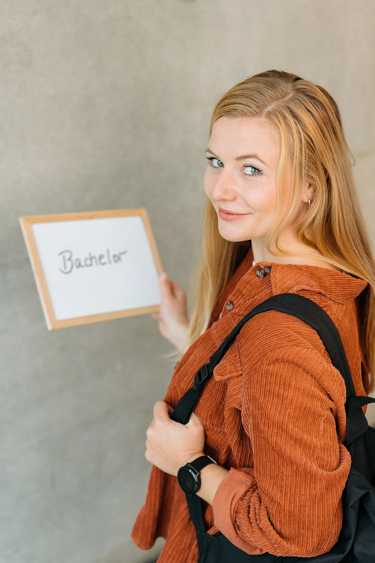 Bachelor-Studentin mit Schild