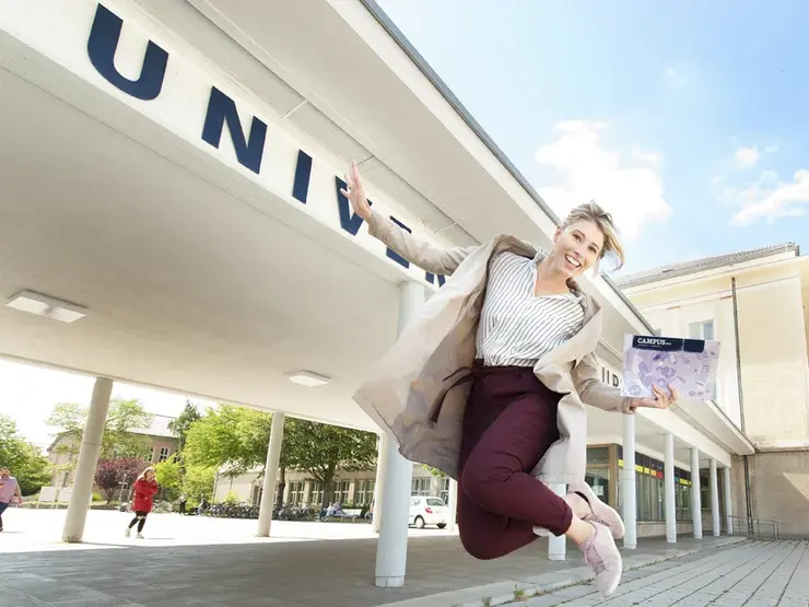 Studentin vor Haupteingang