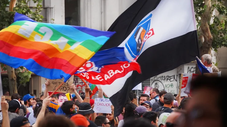 Demonstration in Chile. Demonstranten schwingen Friedensflaggen und welche von Fußballvereinen.