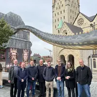 Die Exkursionsgruppe vor dem Dinosaurier Diplodocus.