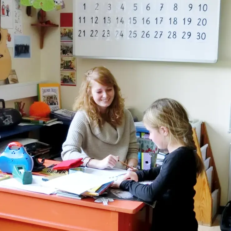 Eine Lehramtsstudentin unterrichtet ein Kind