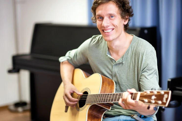 Student mit der Gitarre an der Uni Erfurt