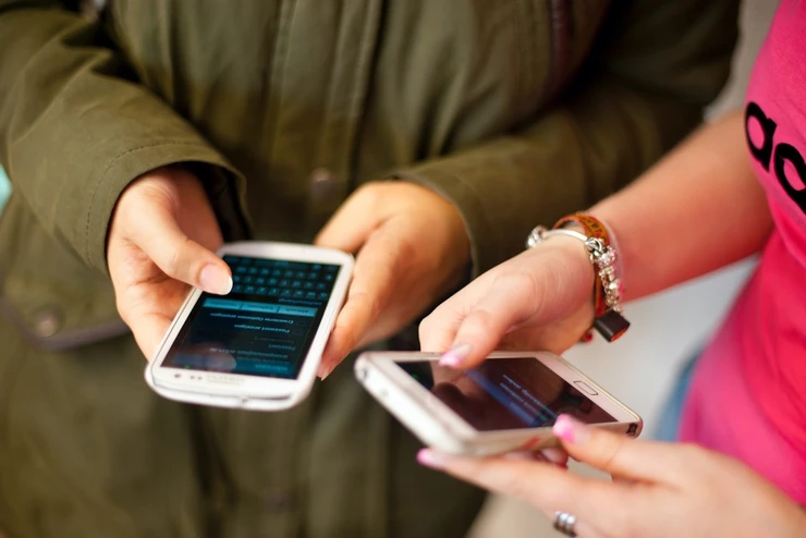 Zwei Personen mit Mobiltelefonen