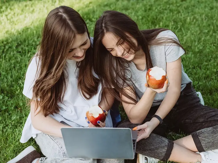 Studentinnen mit Laptop und APfel