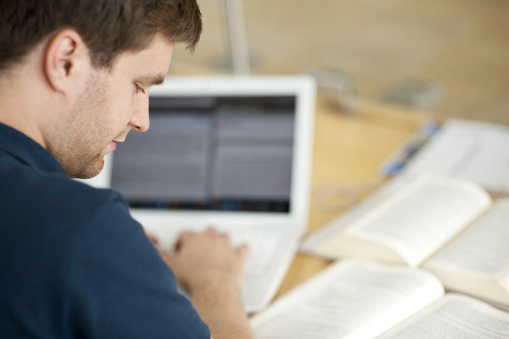 Ein Student arbeitet an einem Laptop in der Universitätsbibliotek der Universität Erfurt