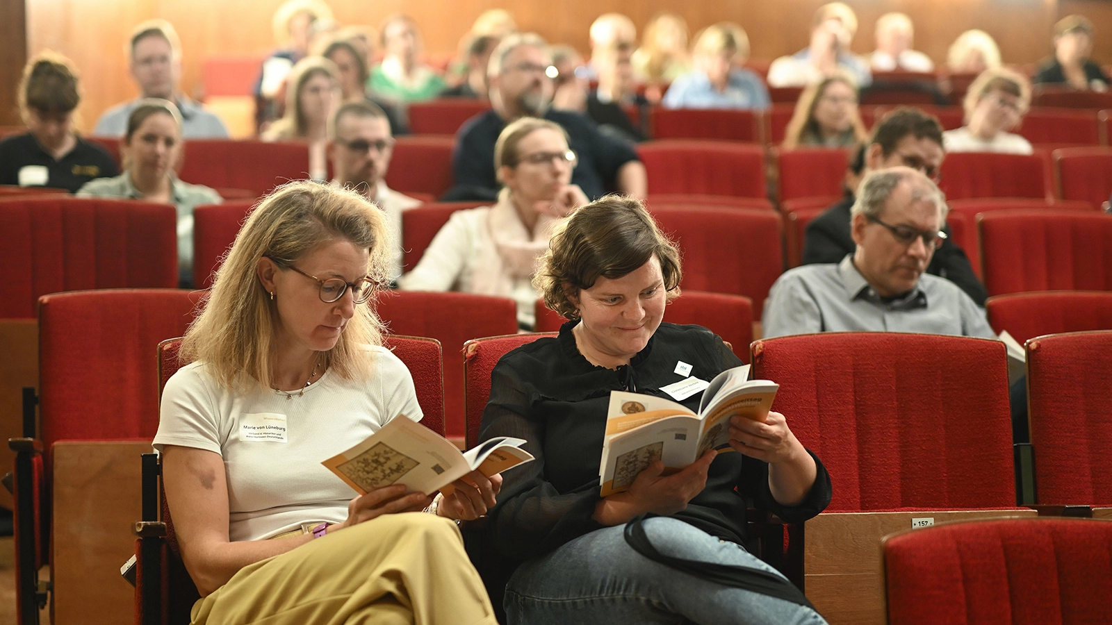 Teilnehmer:innen sitzen im Theatersaal des Kulturhauses