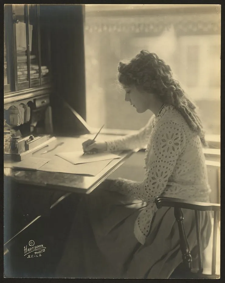 woman sitting at desk writing